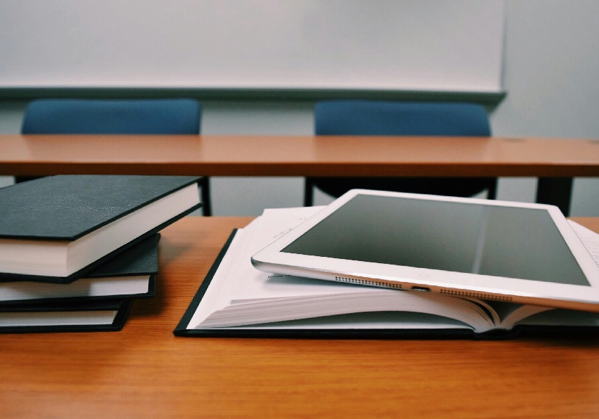 Aula amb llibretes i tablet sobre la taula